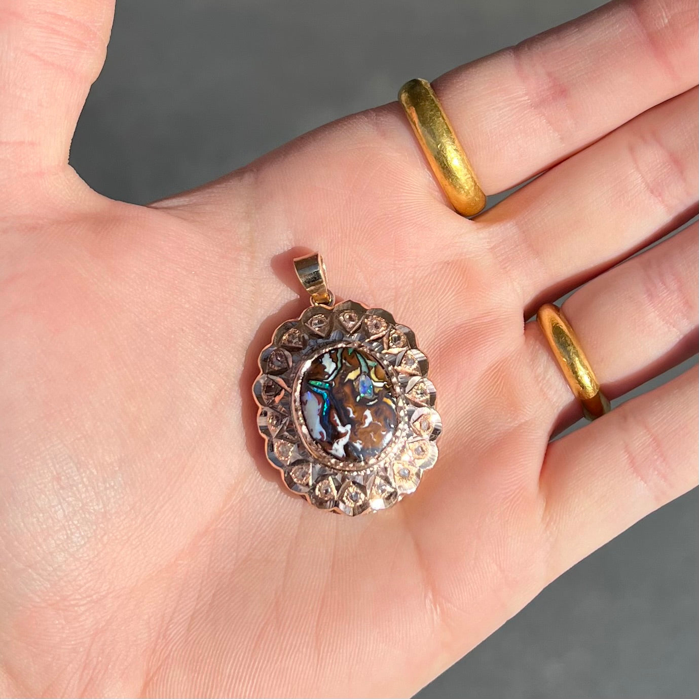 An antique 18 karat yellow gold pendant set with rough diamonds and an oval cut boulder opal from Koroit, Australia.