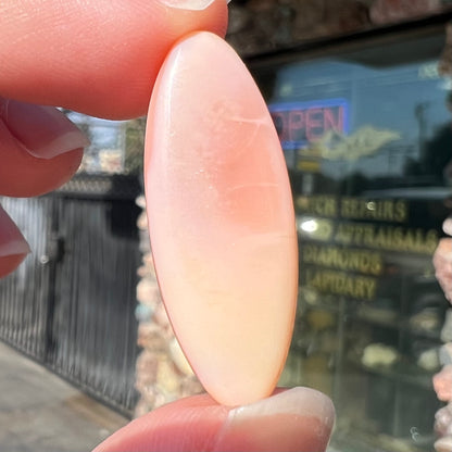 A loose, marquise cabochon cut pink common opal from Peru.  The opal has no play of color.