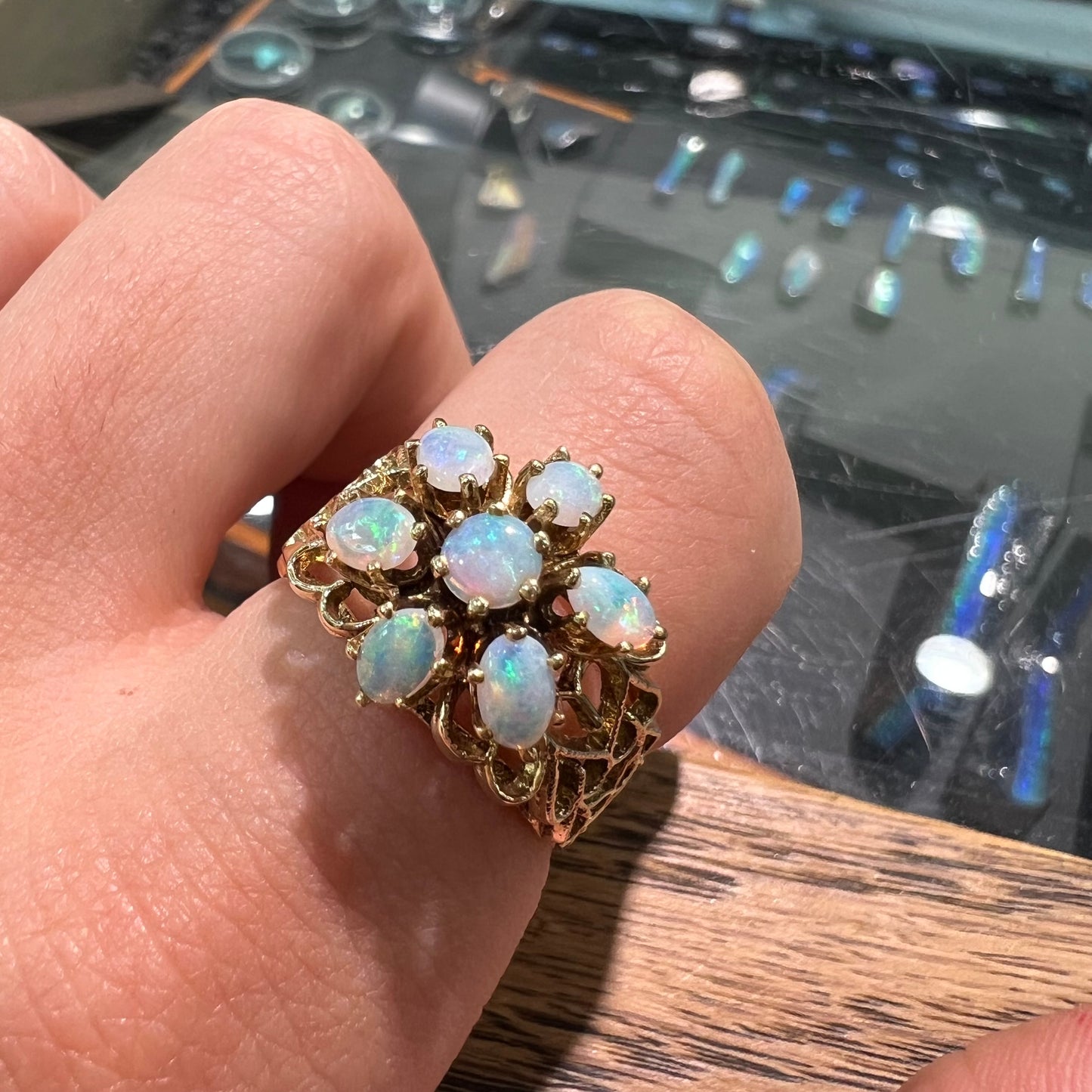 A vintage, 1950's style opal cluster ring cast in yellow gold with a heart shaped filigree design.