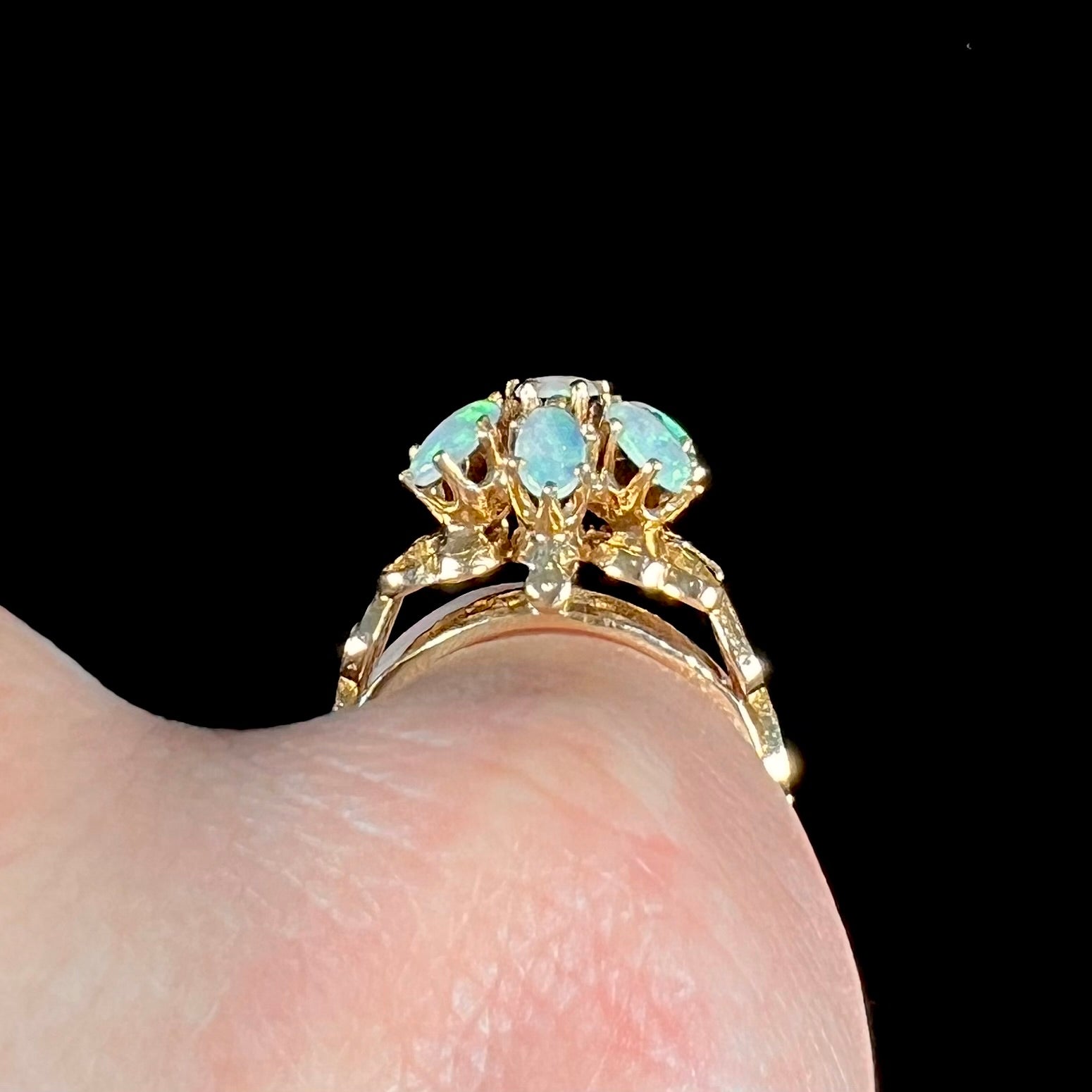 A vintage, 1950's style opal cluster ring cast in yellow gold with a heart shaped filigree design.