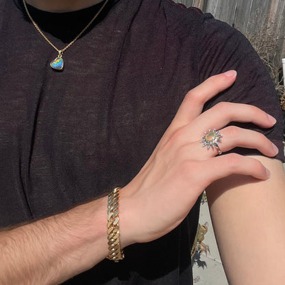 A sterling silver sunburst-style ring mounted with a faceted oval cut Ethiopian fire opal.