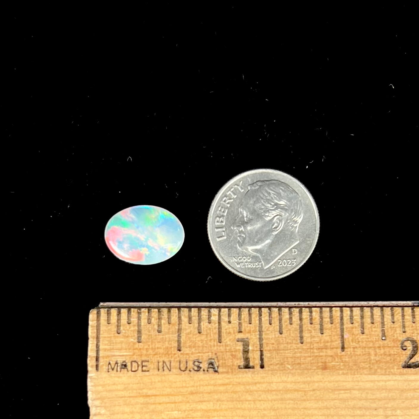 An oval cut opal with red, green, and blue fire from Coober Pedy, Australia.