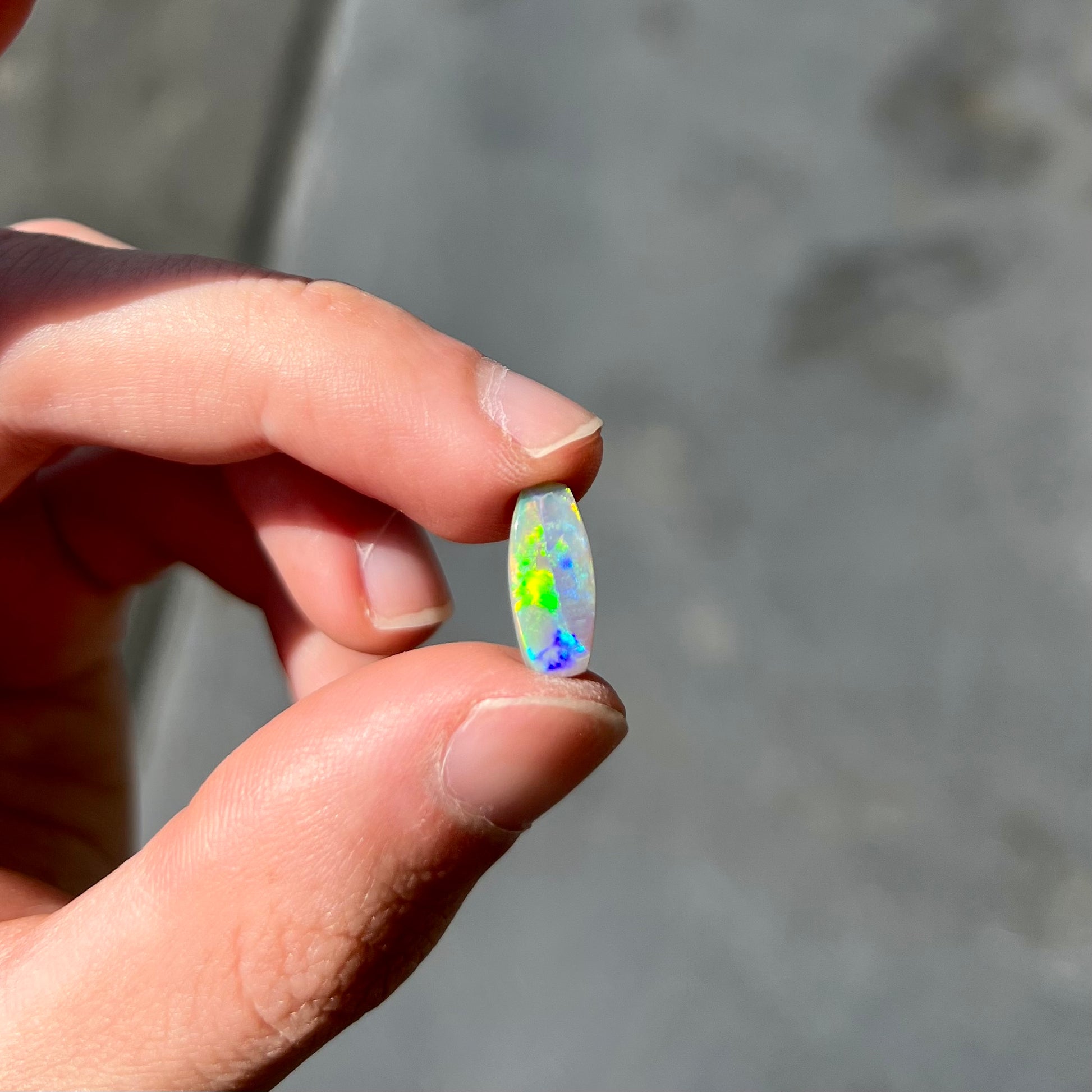 A loose, barrel shaped opal stone from Lightning Ridge, Australia.