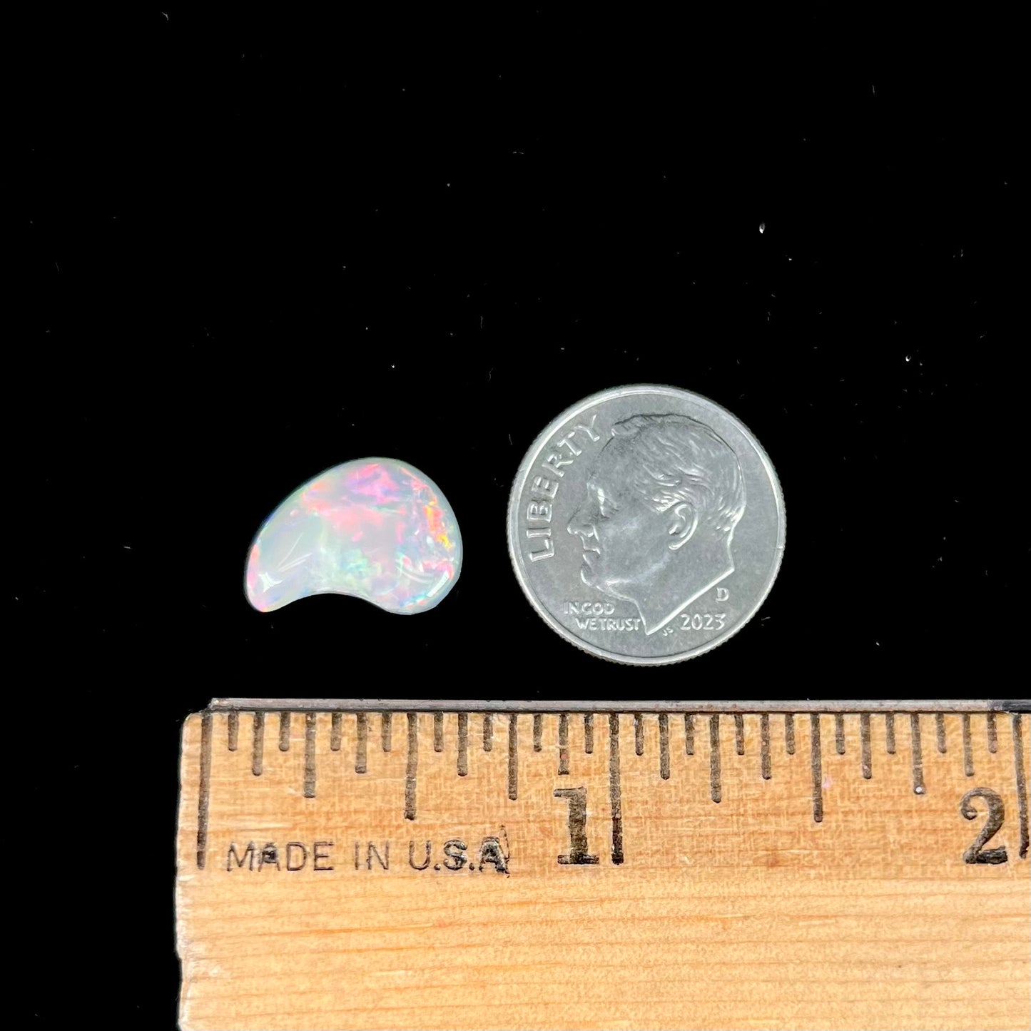 A loose, drop shaped opal stone from Lightning Ridge, Australia.  The stone has bright red fire.