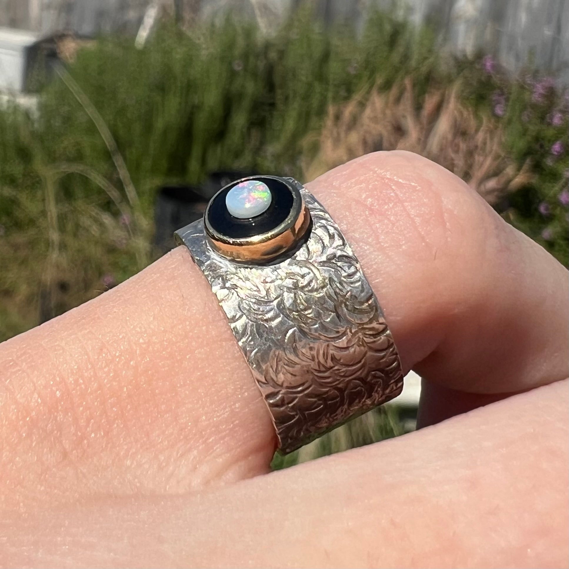 An opal and black onyx inlay ring in a sterling silver cigar-style pinkie ring.