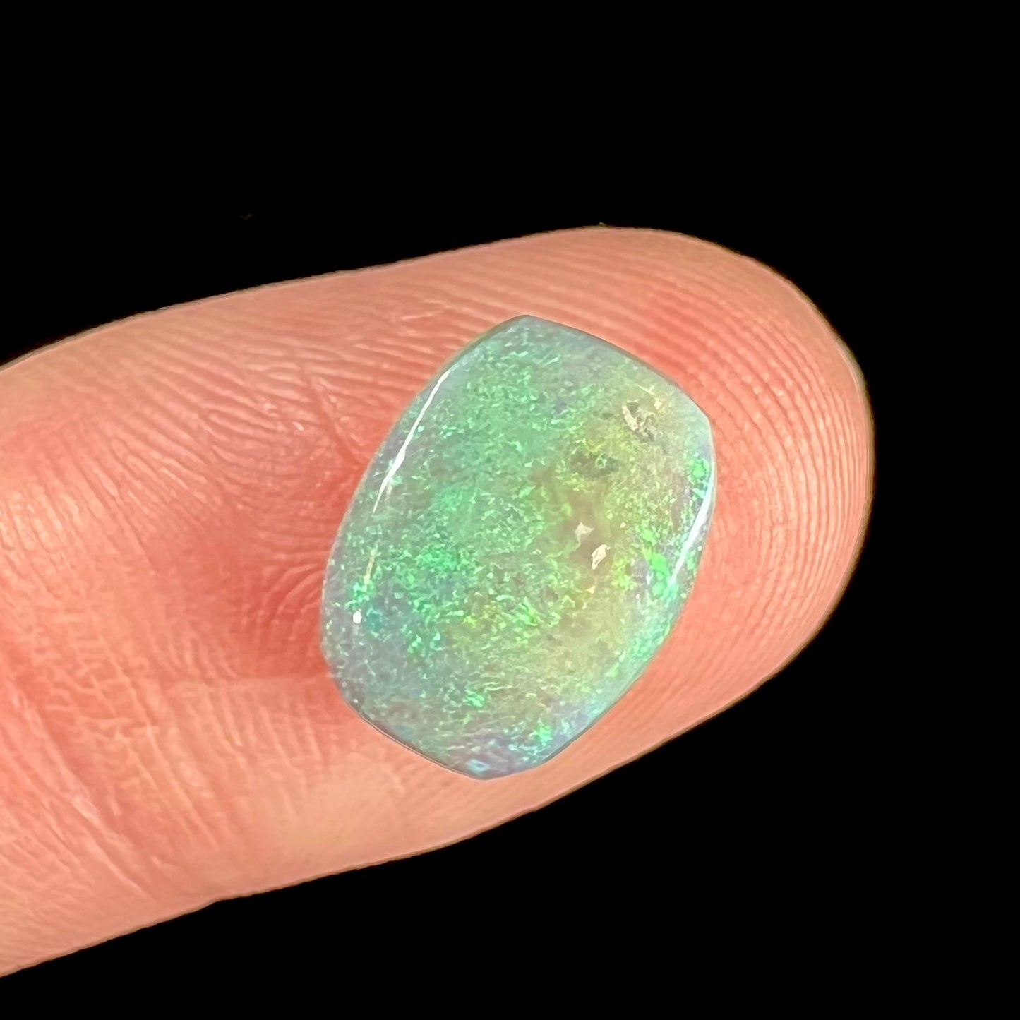 A 2.40ct barrel shaped Lightning Ridge semi-crystal opal.  The stone has blue and green colors.