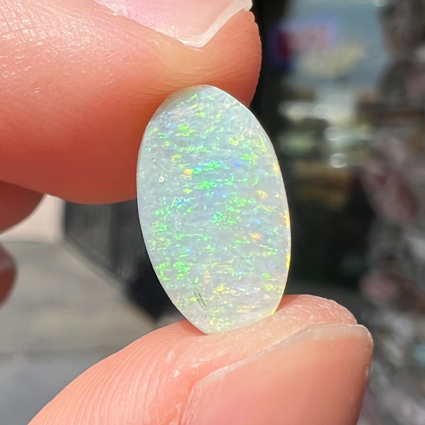 A loose, oval cabochon cut white opal stone from Coober Pedy, Australia.