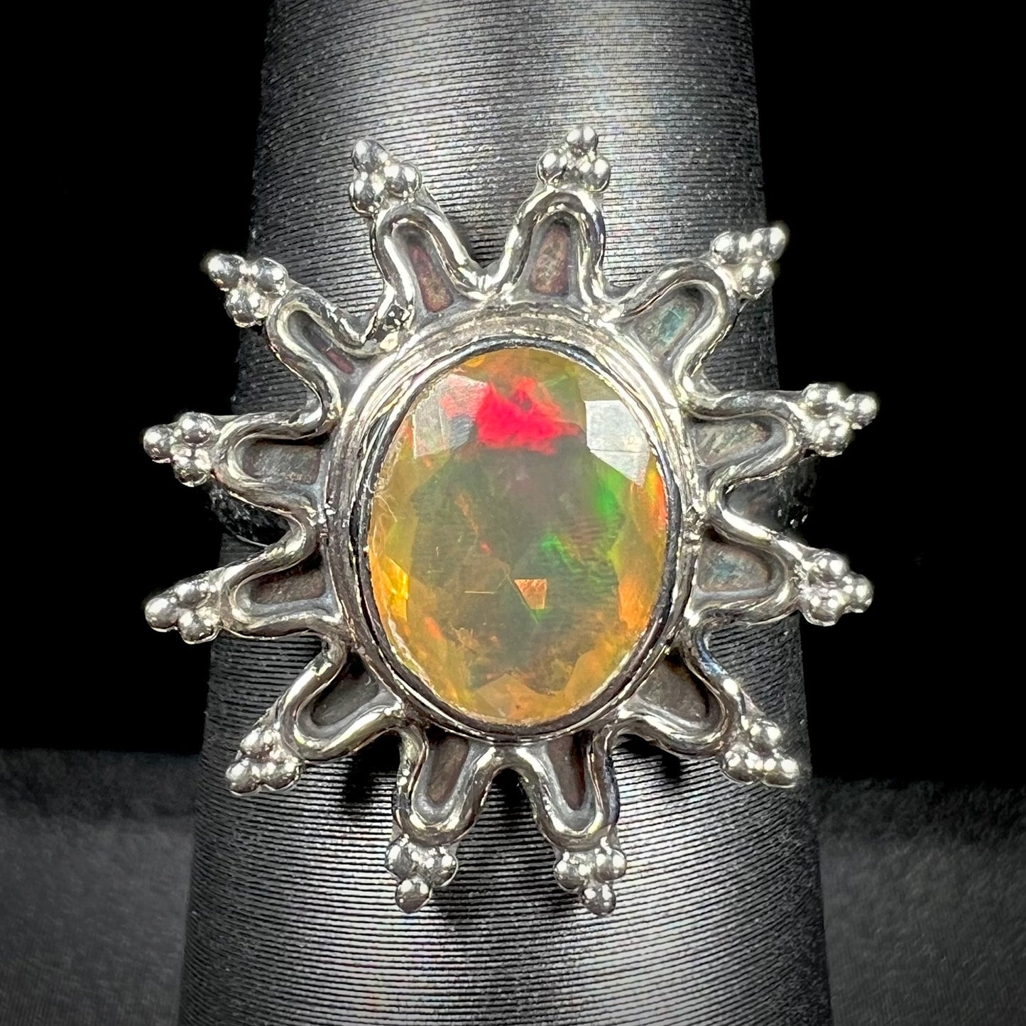 A sterling silver sunburst-style ring mounted with a faceted oval cut Ethiopian fire opal.