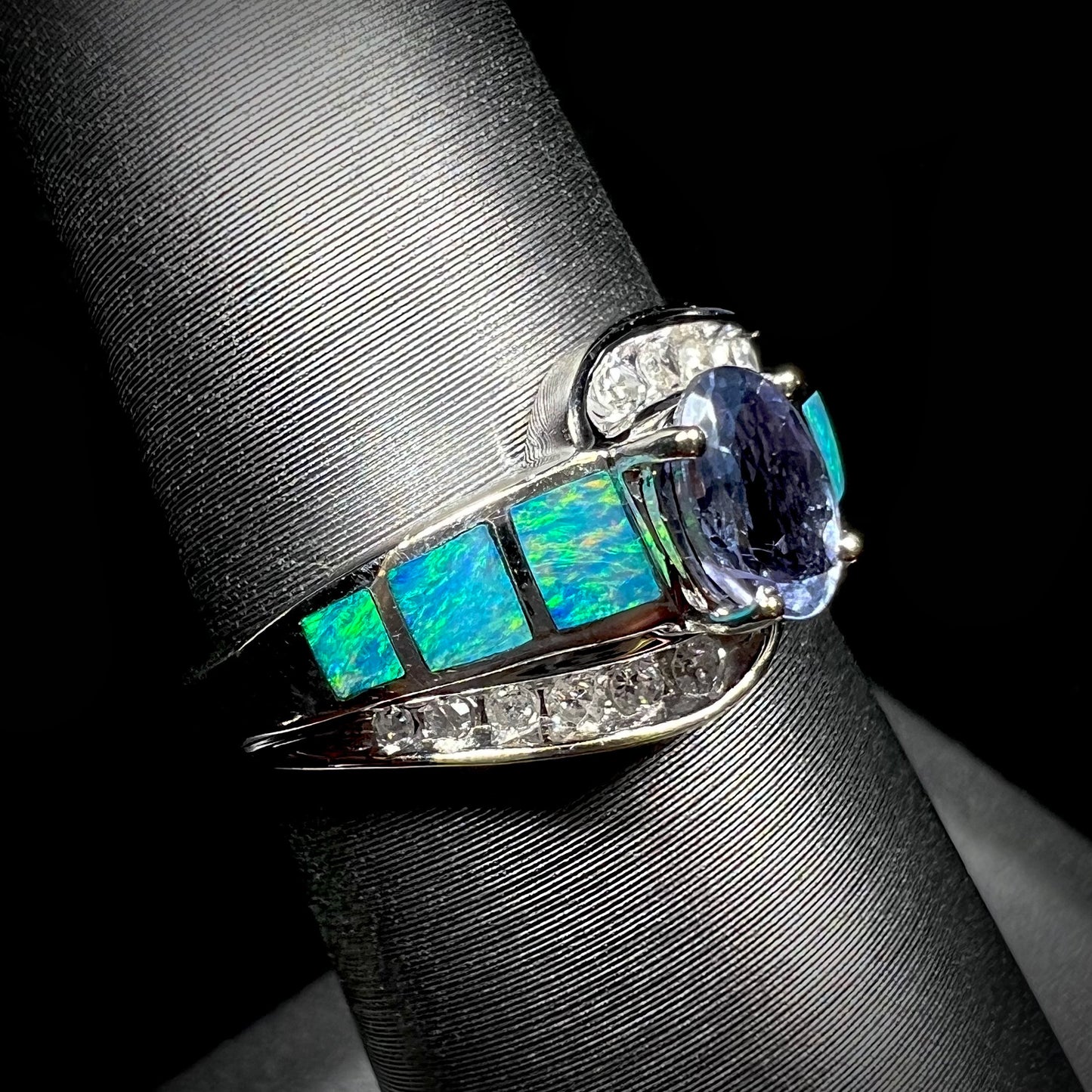 A ladies' white gold tanzanite ring with black opal doublet and diamond accents.