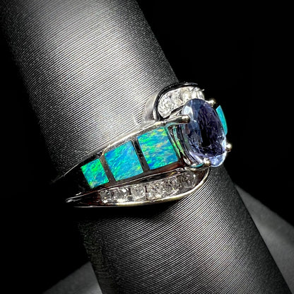 A ladies' white gold tanzanite ring with black opal doublet and diamond accents.