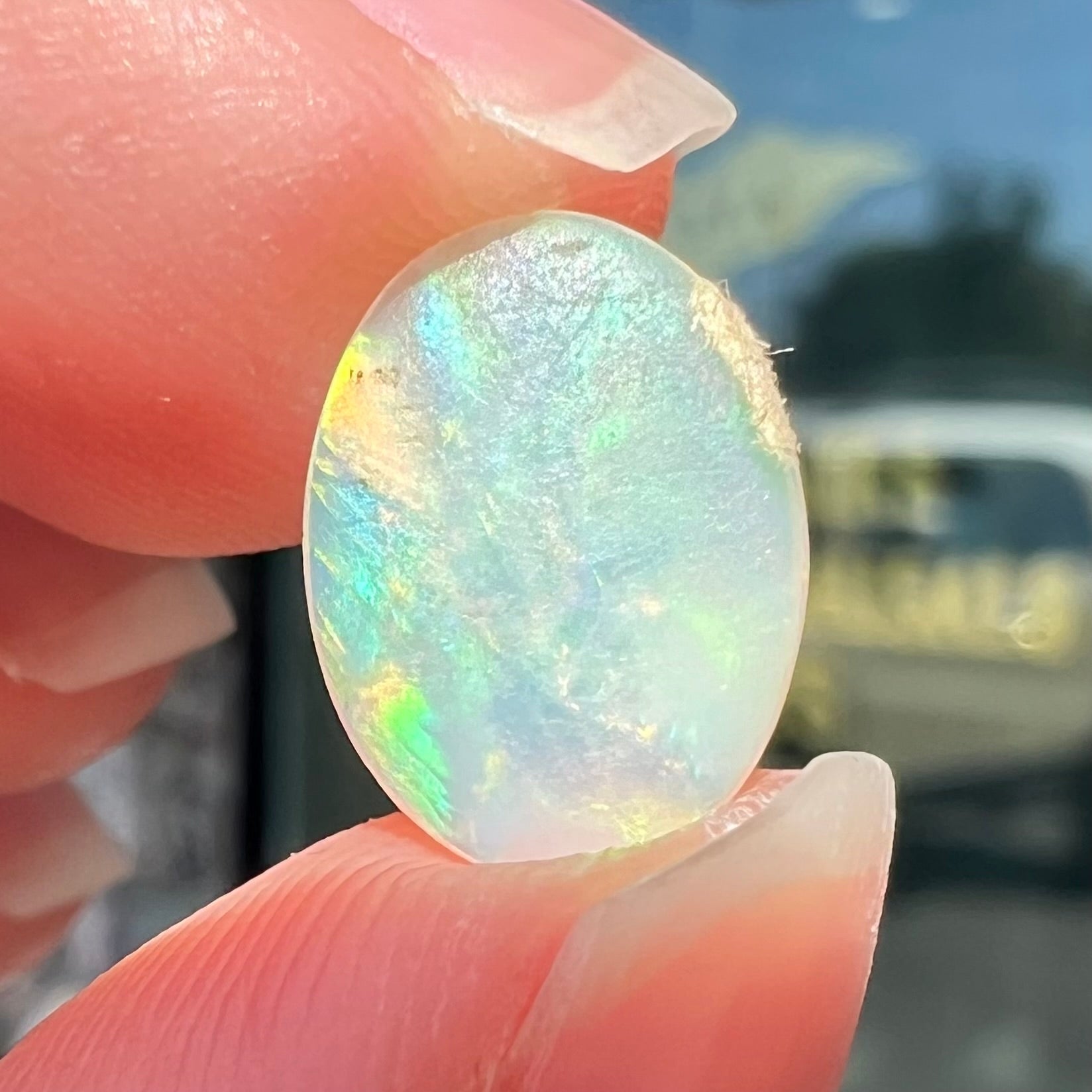 An oval cut opal with red, green, and blue fire from Coober Pedy, Australia.