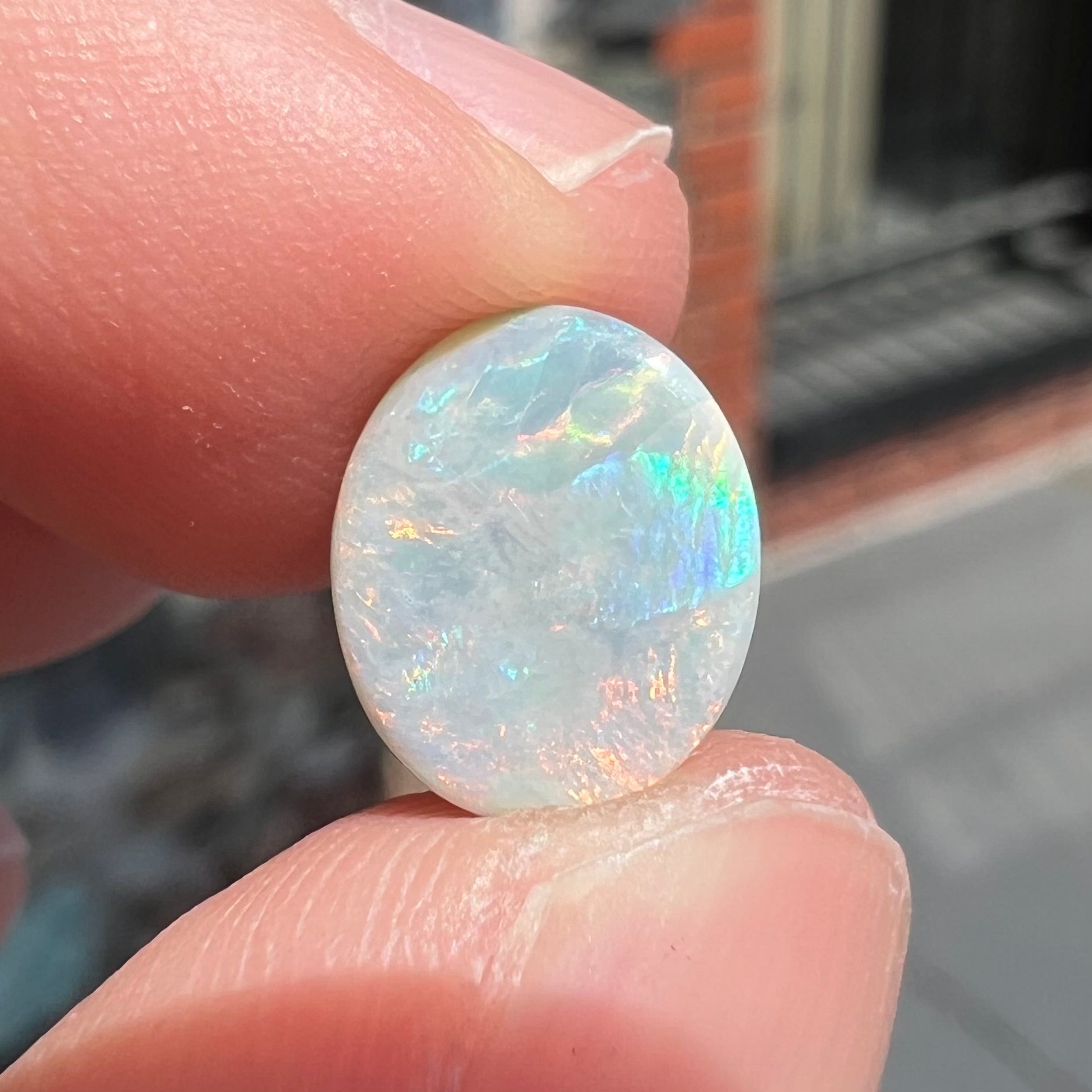 A loose, oval cabochon cut Lightning Ridge light opal stone.