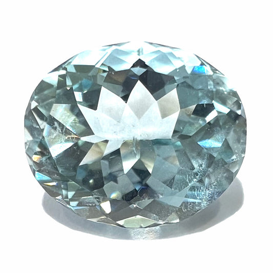 A loose, faceted oval cut aquamarine gemstone from Brazil.  The stone is a greenish blue color and weighs 5.88 carats.