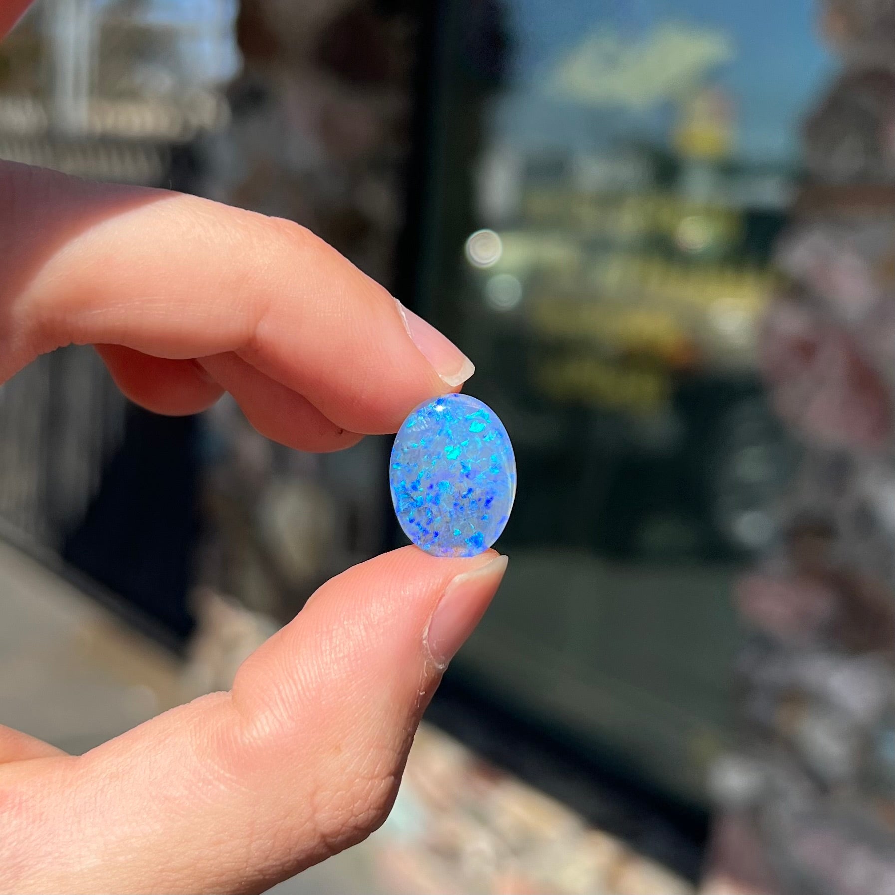 A loose, oval cabochon cut crystal opal from Lightning Ridge, Austalia that weighs 5.16 carats.  The stone has blue and purple colors.