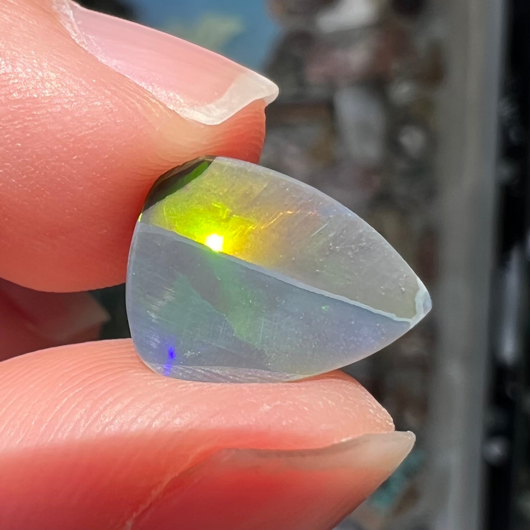 A loose, pear shaped black opal stone from Lightning Ridge, Austalia that weighs 1.19 carats.