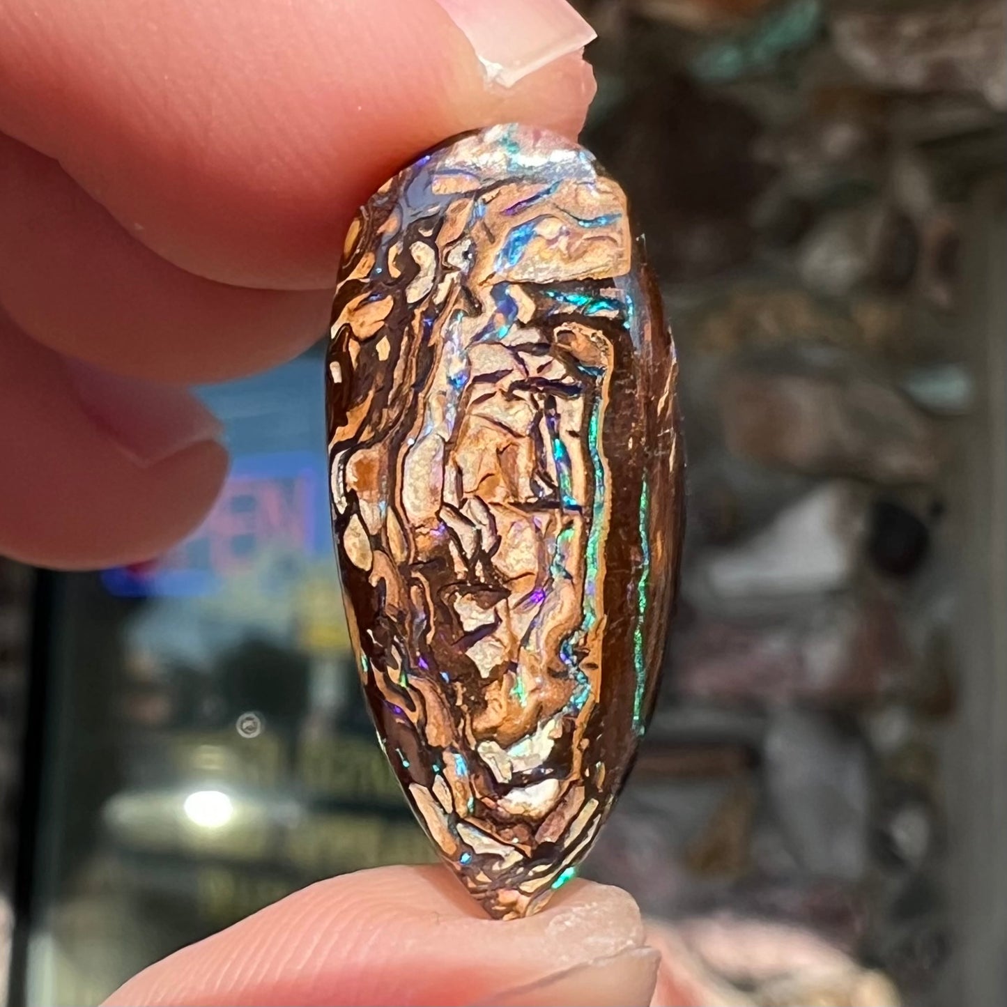 A pear shaped Koroit boulder matrix opal with blue and purple colors in veins.