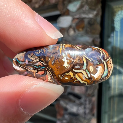 A polished, pear shaped boulder opal stone from Koroit, Australia. 