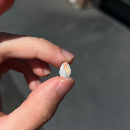 A loose, pear shaped Australian white opal stone.  The stone plays every color of the rainbow.