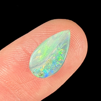 A loose, pear shaped Australian opal stone.  The opal shows green and blue colors.