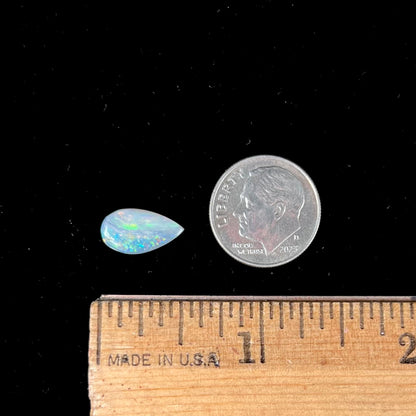 A loose, pear shaped Australian opal stone.  The opal shows green and blue colors.