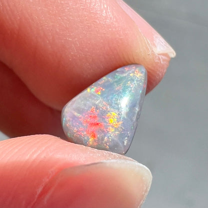 A loose, pear shaped black opal stone with red fire.