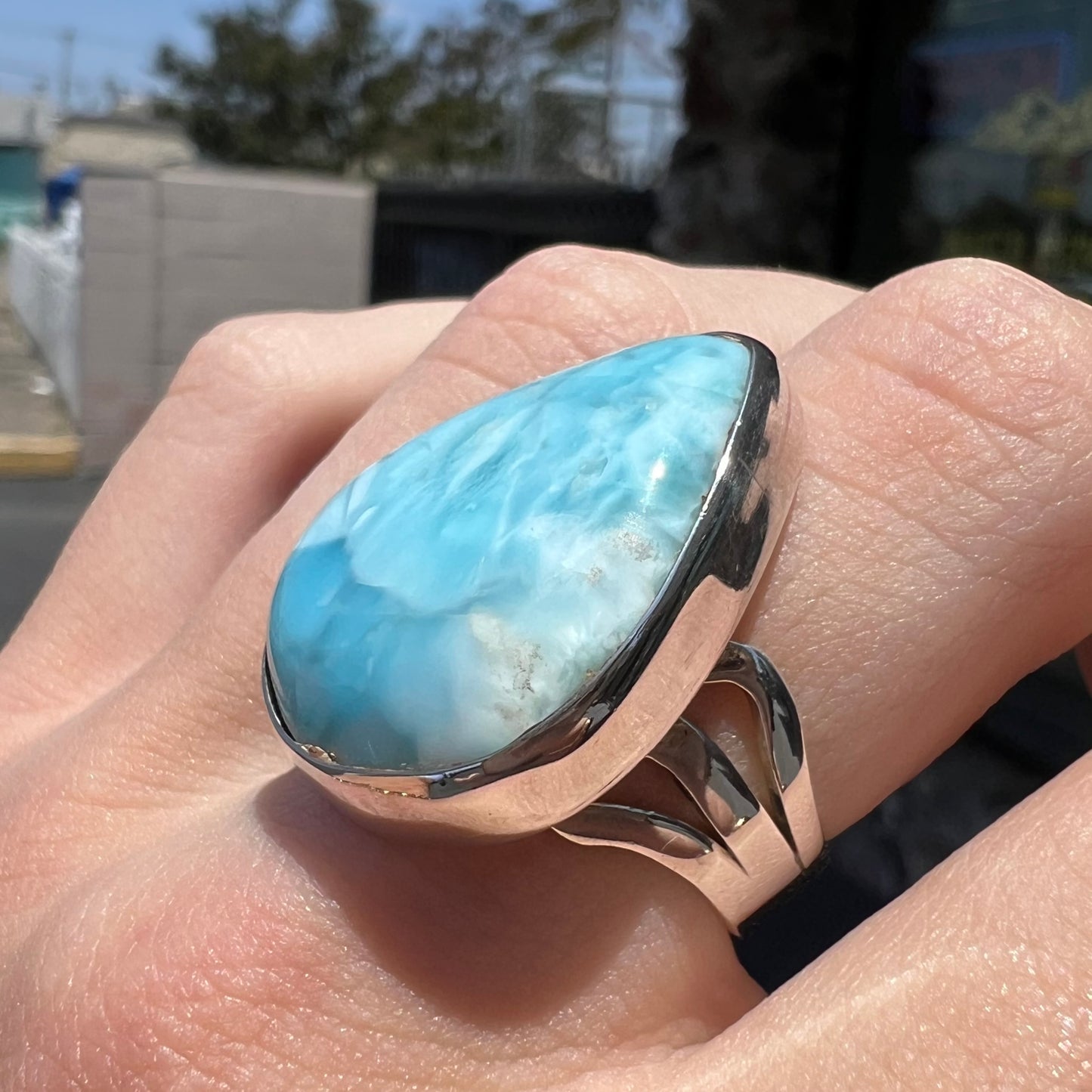 A ladies' large, pear shaped larimar solitaire ring in sterling silver.  The larimar stone measures an inch long.