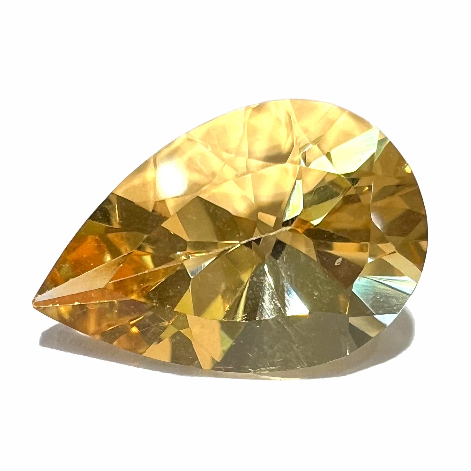 A loose, golden yellow, pear shaped citrine gemstone.  The citrine is yellow and weighs 4.94 carats.