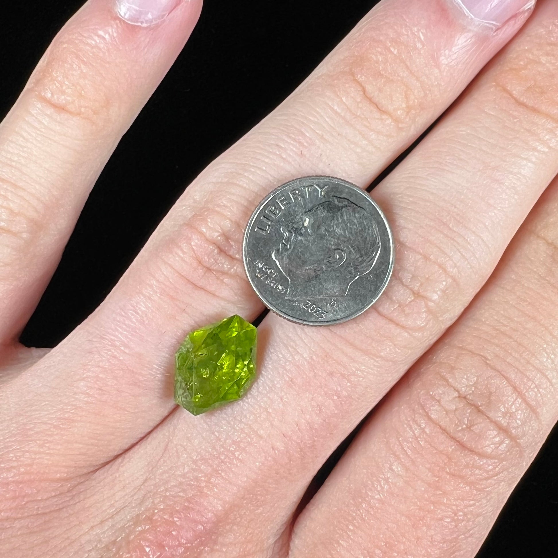 A loose, modified octagon peridot stone.  The stone is a yellow green color.