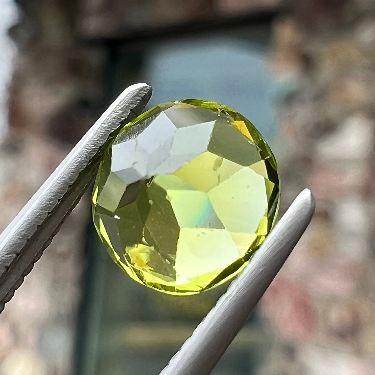 A loose, round brilliant cut peridot gemstone.