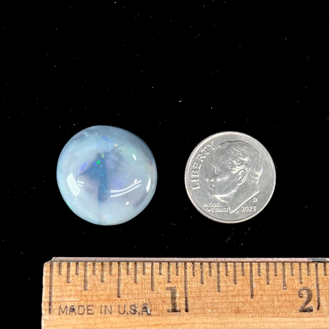 A round cabochon cut Lightning Ridge opal stone that has a picture of a bird of paradise.