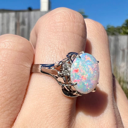 A platinum  and diamond ring prong-set with an Australian opal.  The opal has pink color play.