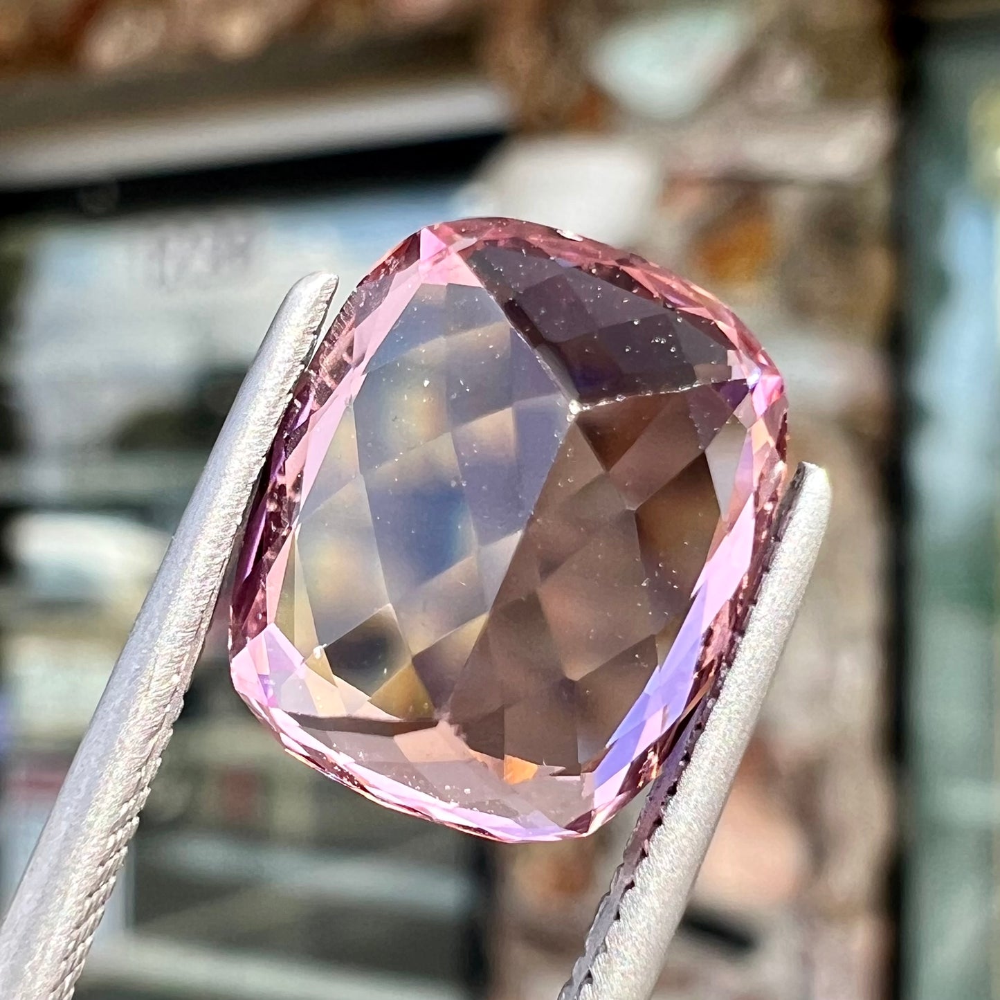 A loose, cushion cut light pink tourmaline gemstone.