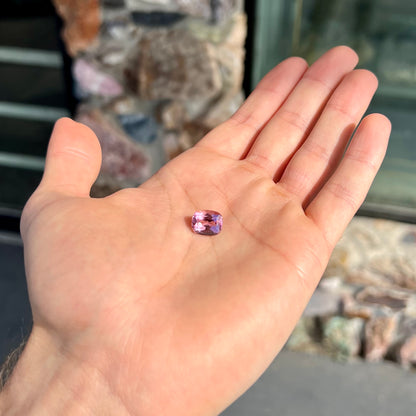 A loose, cushion cut light pink tourmaline gemstone.