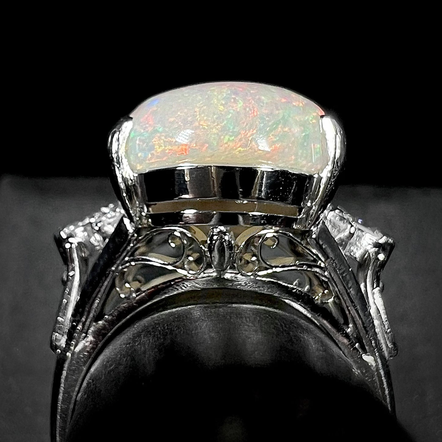 A platinum statement ring mounted with a 7.97ct Coober Pedy opal and marquise cut diamond accents.