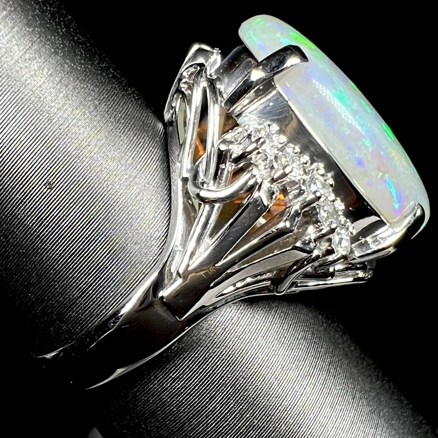 A platinum filigree ring set with a large, green-blue Mintabie crystal opal and diamonds.