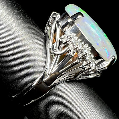 A platinum filigree ring set with a large, green-blue Mintabie crystal opal and diamonds.