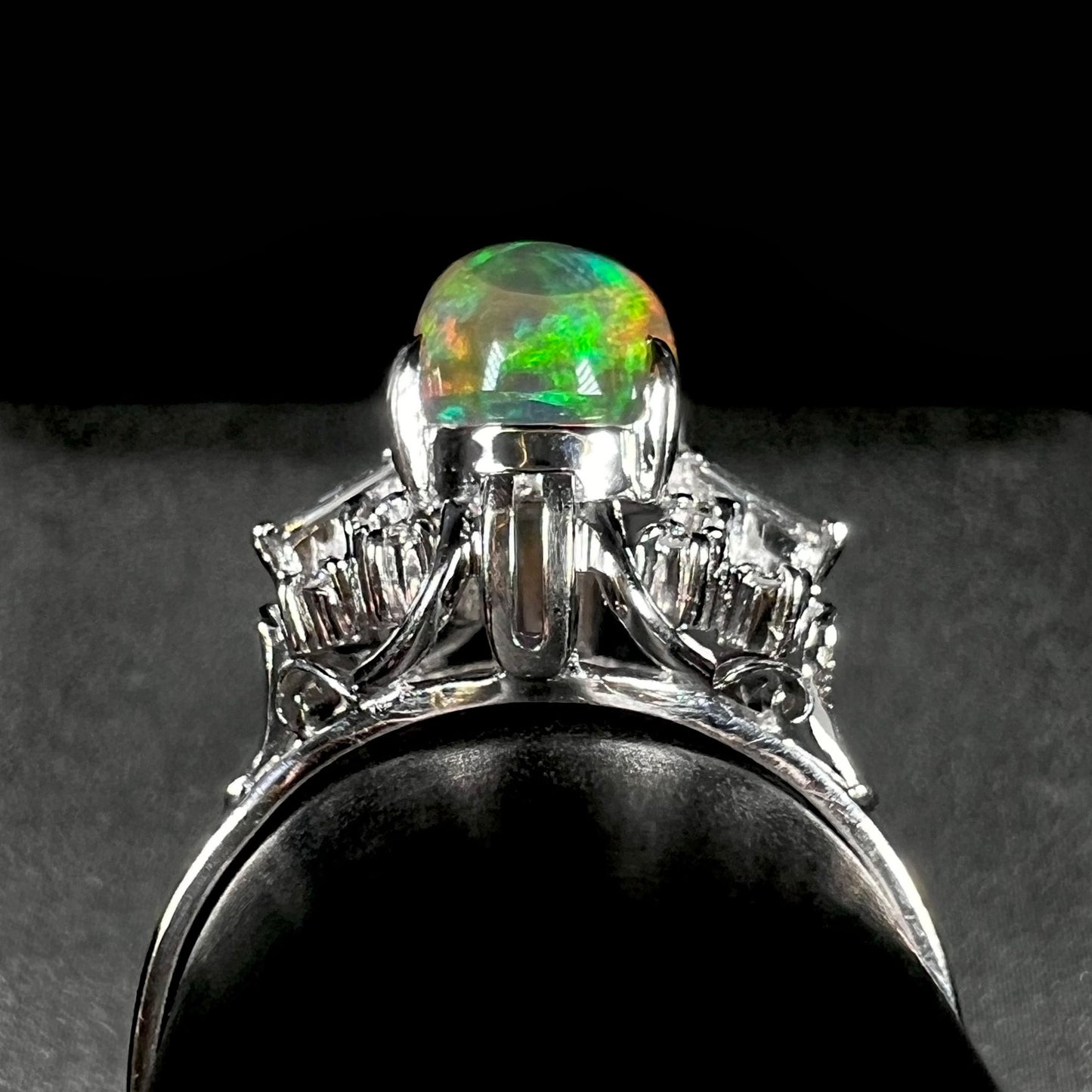 A platinum filigree ring mounted with a high-domed Mexican fire opal and baguette cut diamond accents.