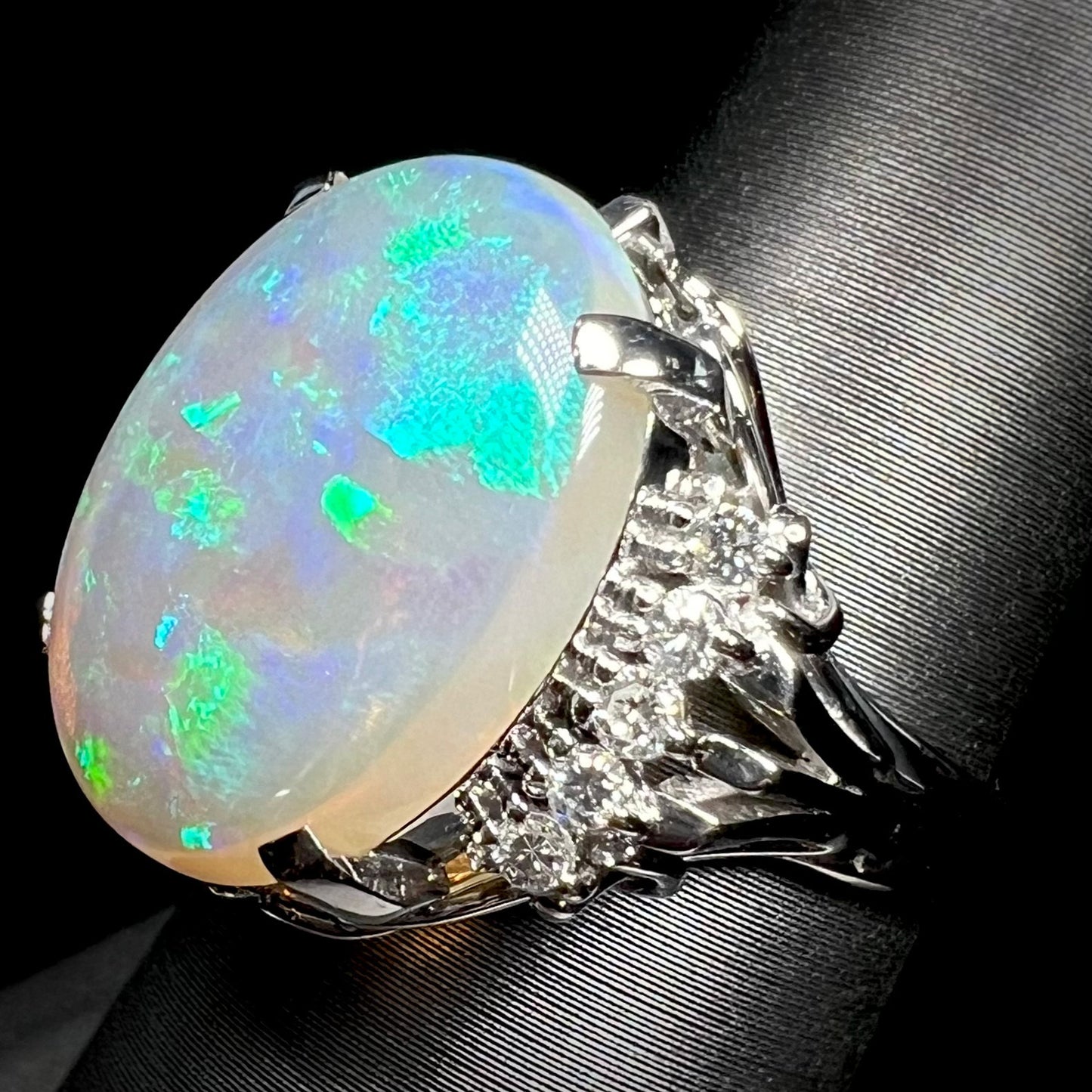 A platinum filigree ring set with a large, green-blue Mintabie crystal opal and diamonds.