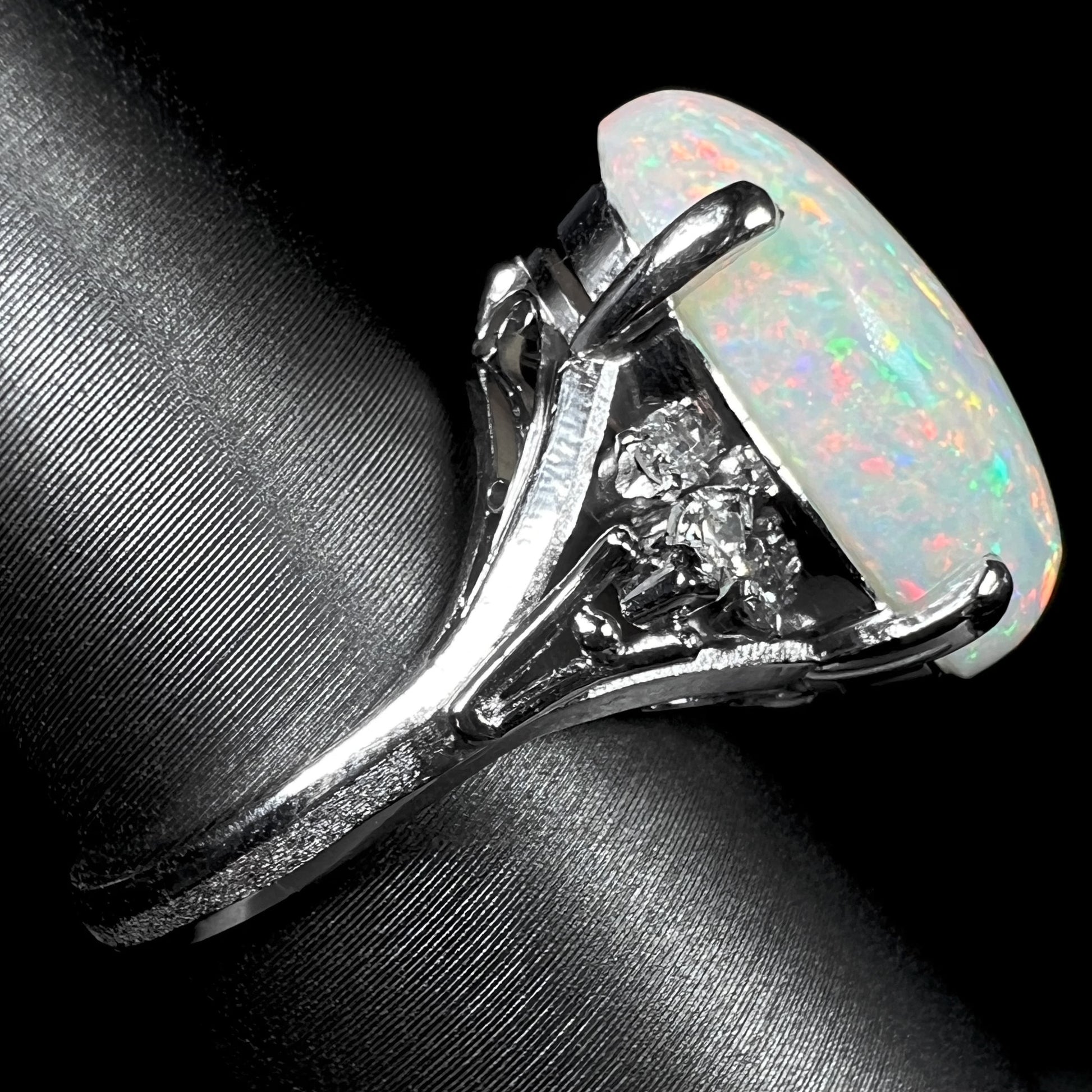 A platinum statement ring mounted with a 7.97ct Coober Pedy opal and marquise cut diamond accents.