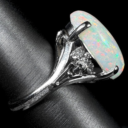 A platinum statement ring mounted with a 7.97ct Coober Pedy opal and marquise cut diamond accents.