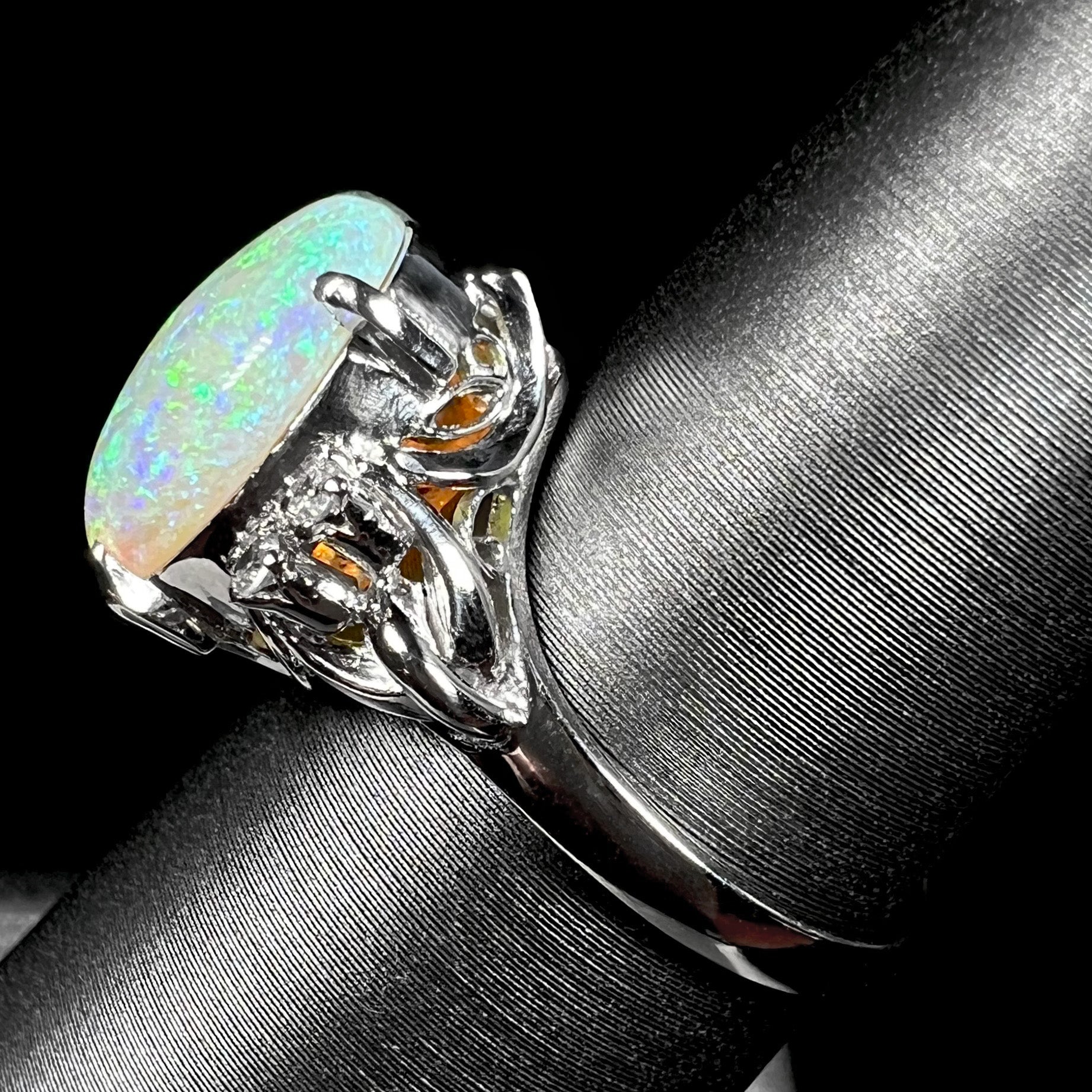 An Australian crystal opal and diamond engagement ring set in a platinum filigree mounting.  The opal plays green/blue colors and has a crack.