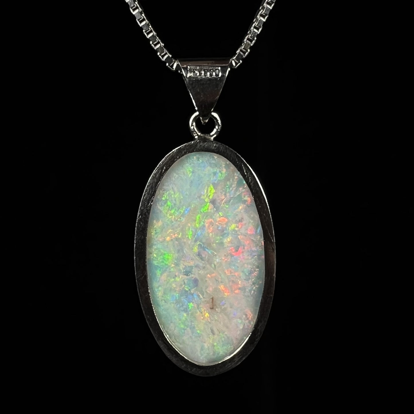 The back of a platinum pendant mounted with an oval cut Australian white opal.