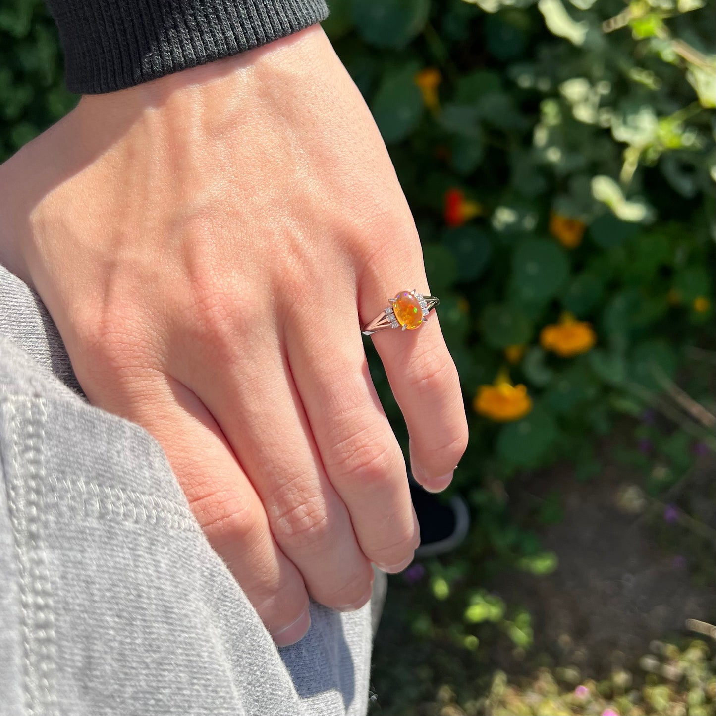 A platinum filigree and diamond-accented Mexican fire opal ring.  The opal is orange with green fire.