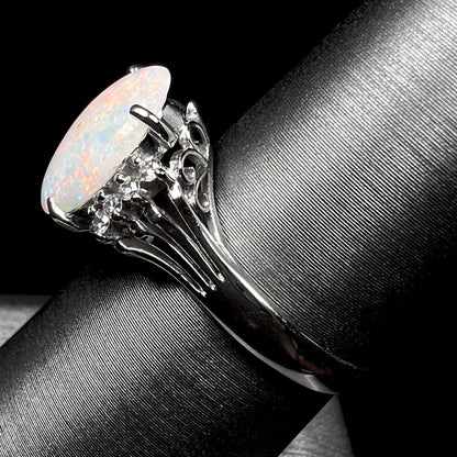 An Australian opal and diamond engagement ring in platinum.  The ring has filigree scrolling.