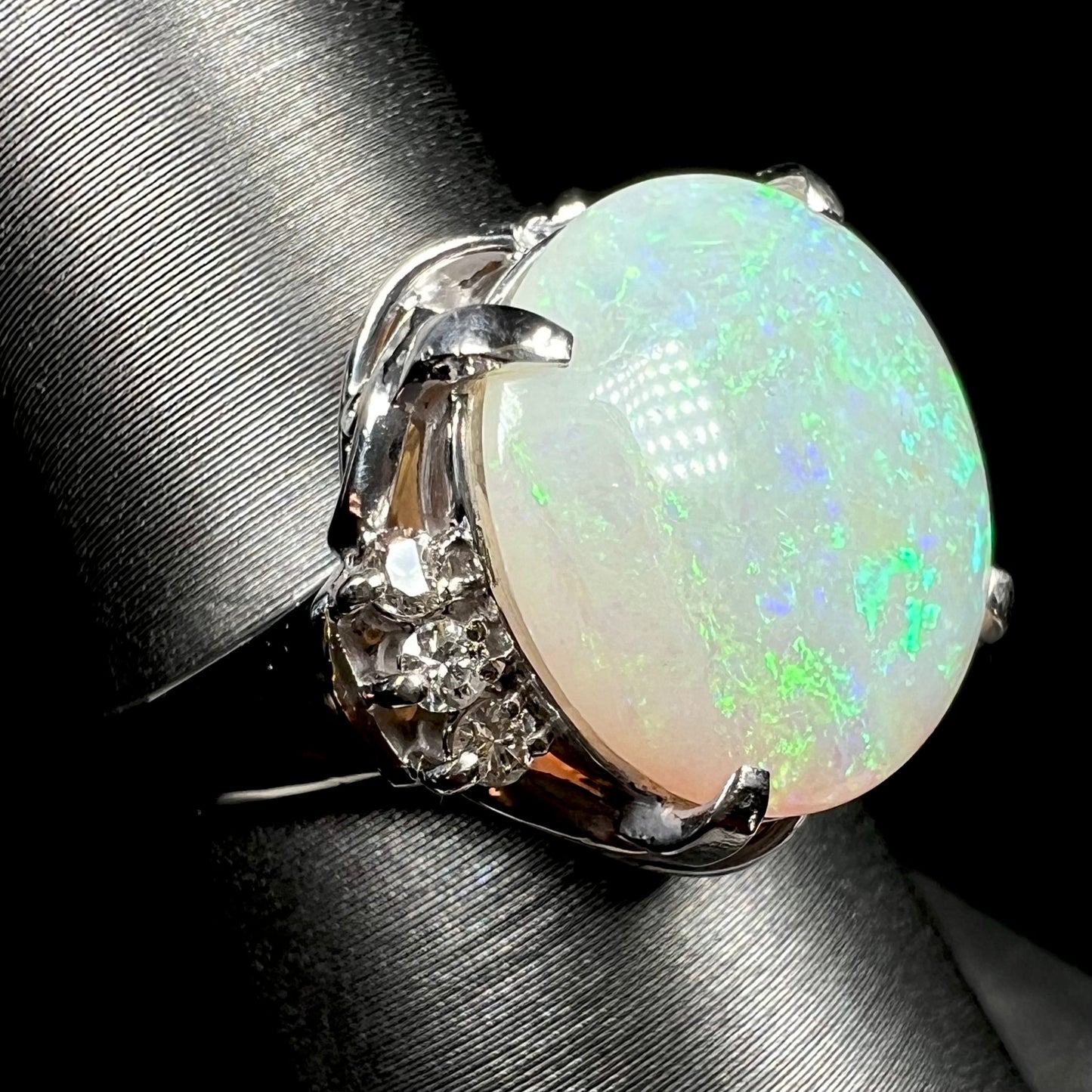 A round cut Australian opal and diamond engagment ring with platinum filigree.