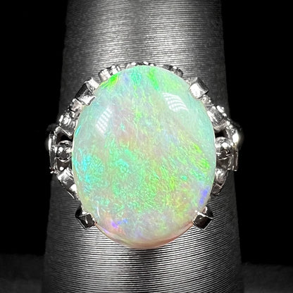 A ladies' Australian opal solitaire engagement ring mounted in platinum.  The opal has green and blue colors.