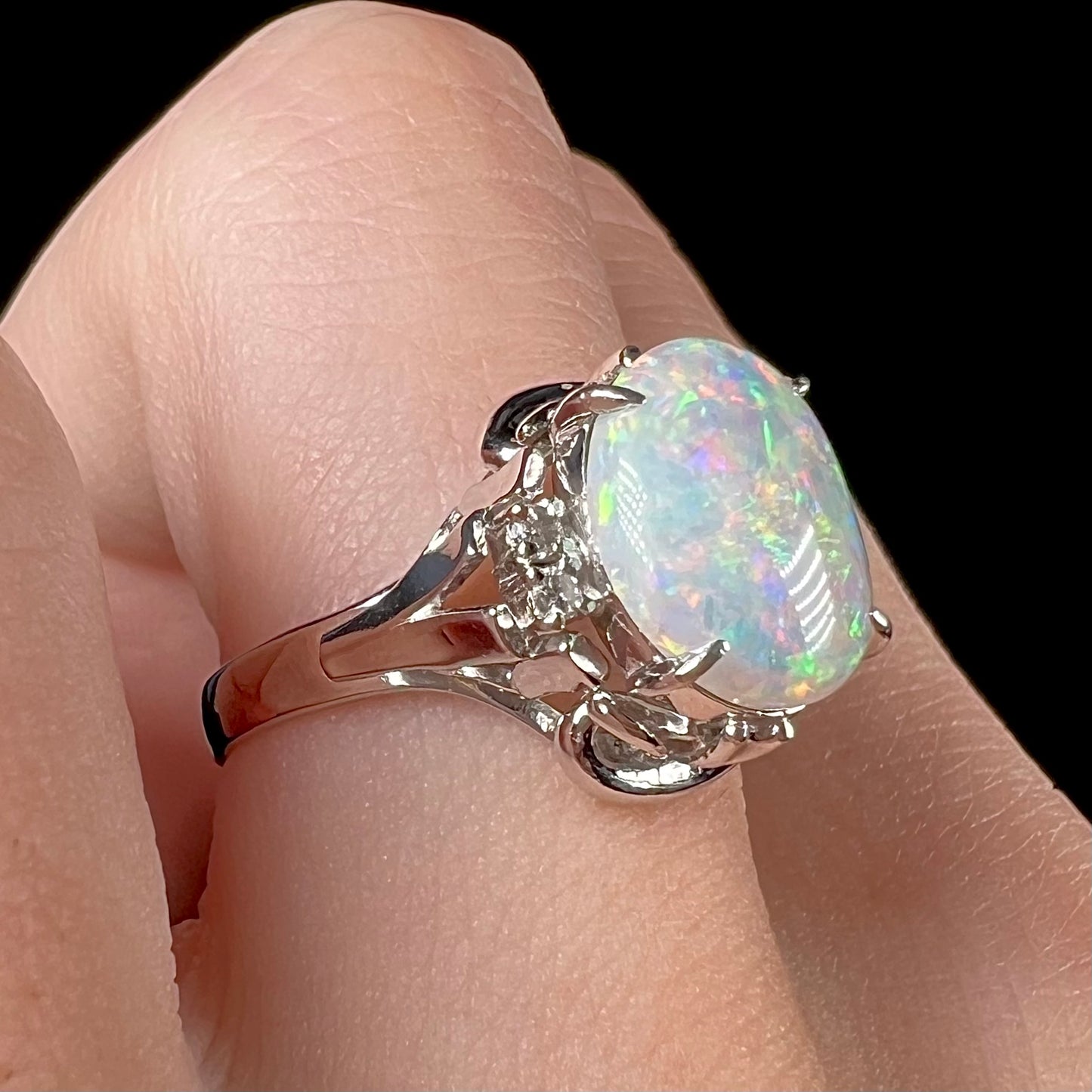 A platinum  and diamond ring prong-set with an Australian opal.  The opal has pink color play.