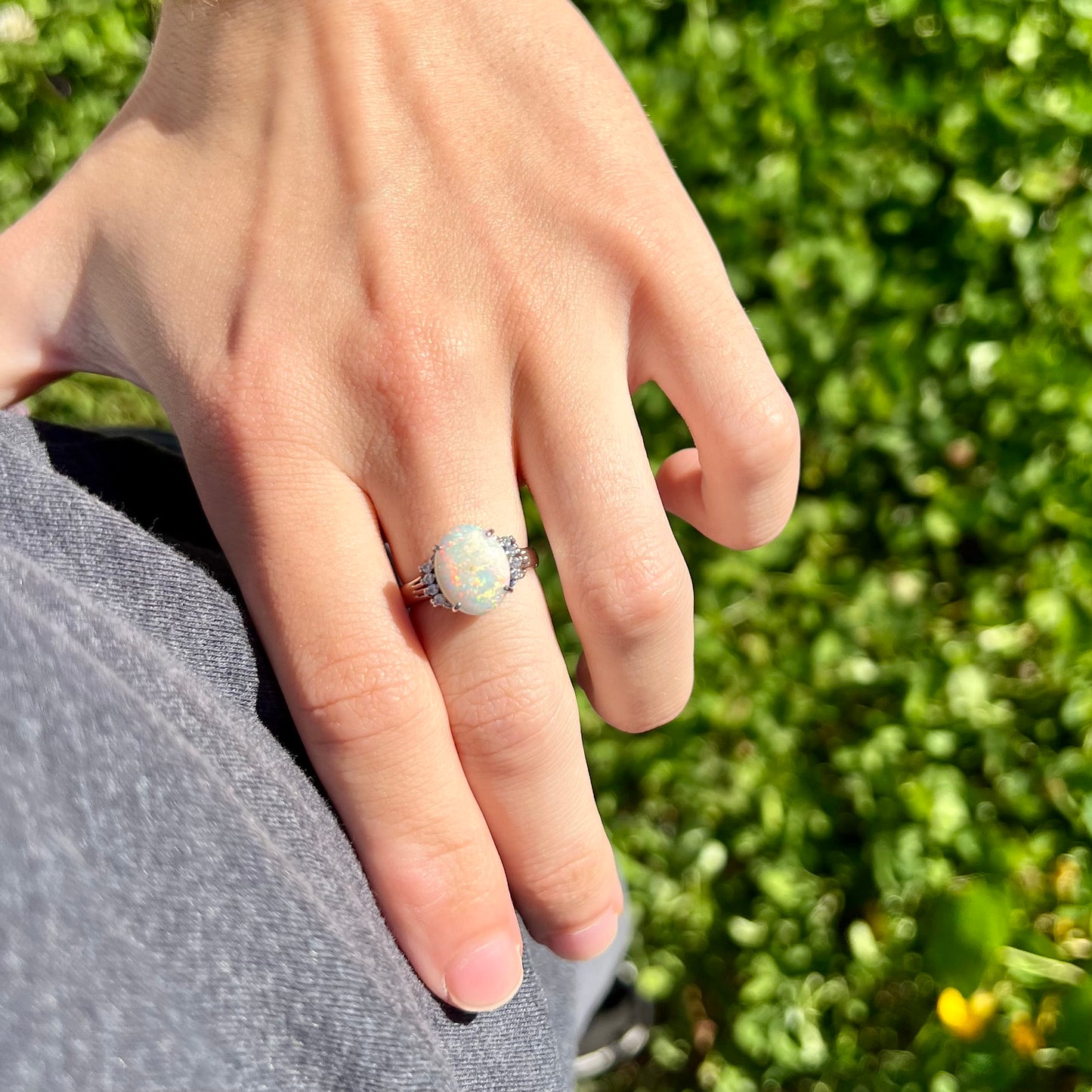 An Australian opal and diamond engagement ring in platinum.  The ring has filigree scrolling.