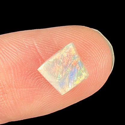 A loose, freeform shaped light opal from Lightning Ridge, Australia.  The opal has an orange color.