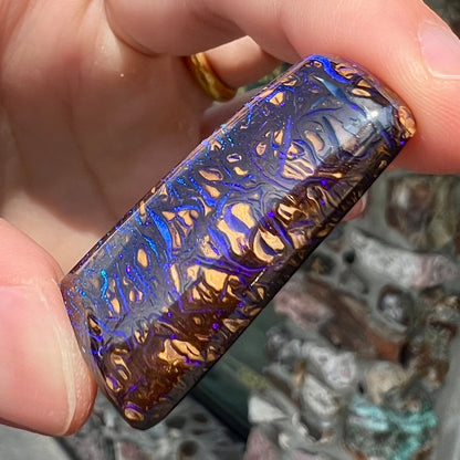 A loose boulder opal stone with purple veins from Koroit, Australia.